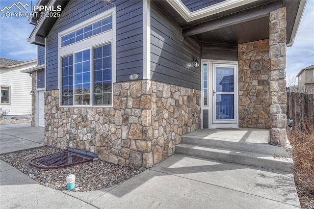 entrance to property with stone siding and concrete driveway