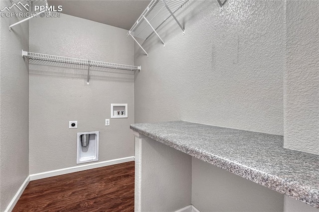 laundry area with baseboards, wood finished floors, washer hookup, laundry area, and a textured wall