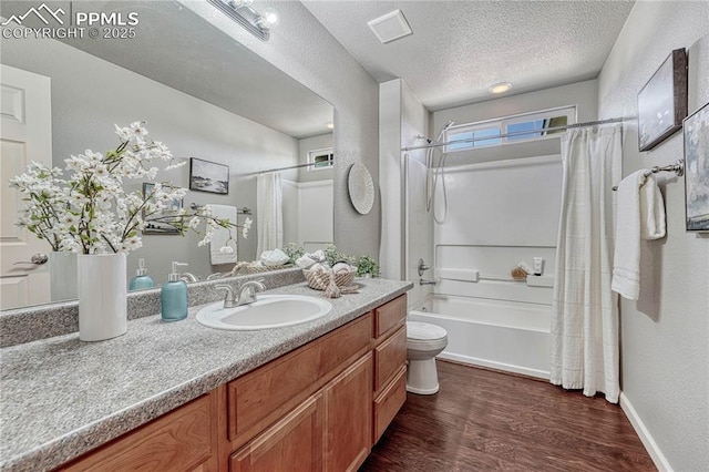 bathroom with toilet, vanity, wood finished floors, a textured ceiling, and shower / bathtub combination with curtain