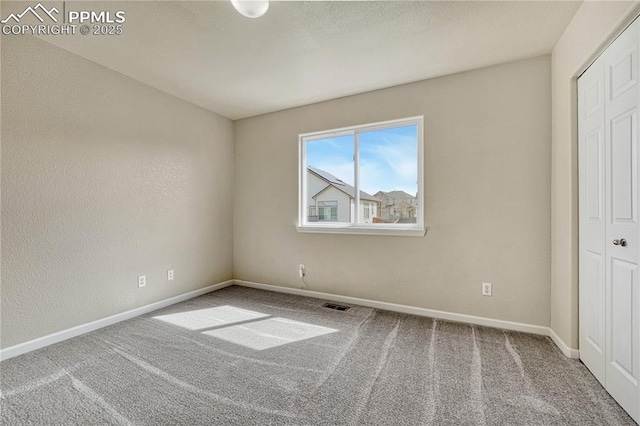 unfurnished bedroom with carpet flooring, visible vents, baseboards, and a closet