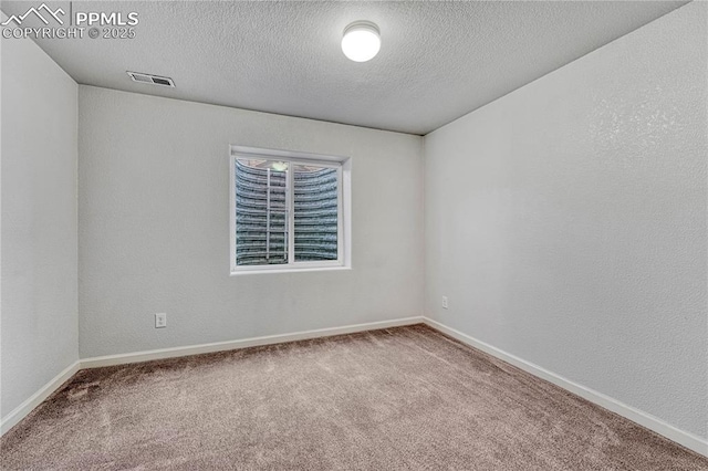 carpeted empty room featuring visible vents, baseboards, and a textured wall