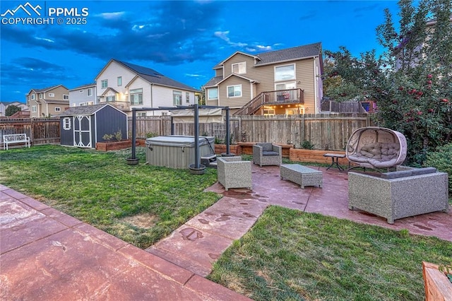 view of yard featuring a hot tub, a shed, a fenced backyard, an outbuilding, and a patio