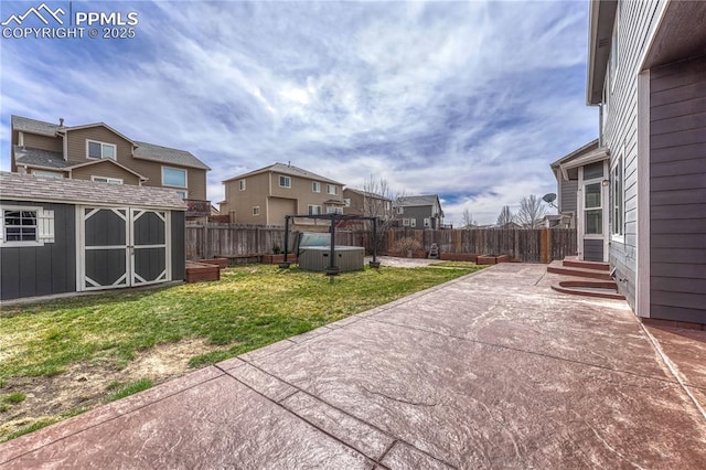 view of patio / terrace with a fenced backyard, entry steps, an outdoor structure, and a shed