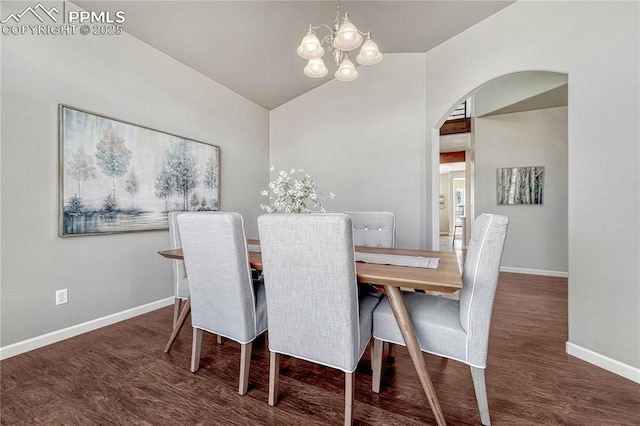 dining area featuring lofted ceiling, wood finished floors, arched walkways, baseboards, and a chandelier