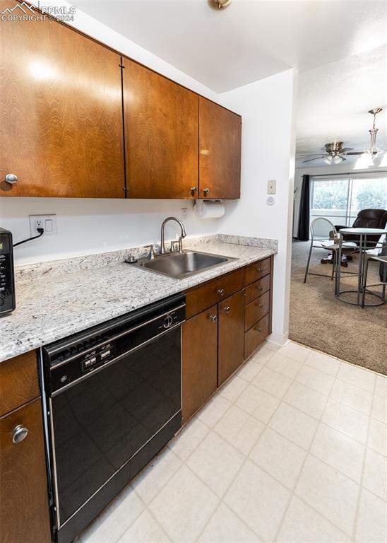 kitchen with light carpet, a ceiling fan, black dishwasher, and a sink