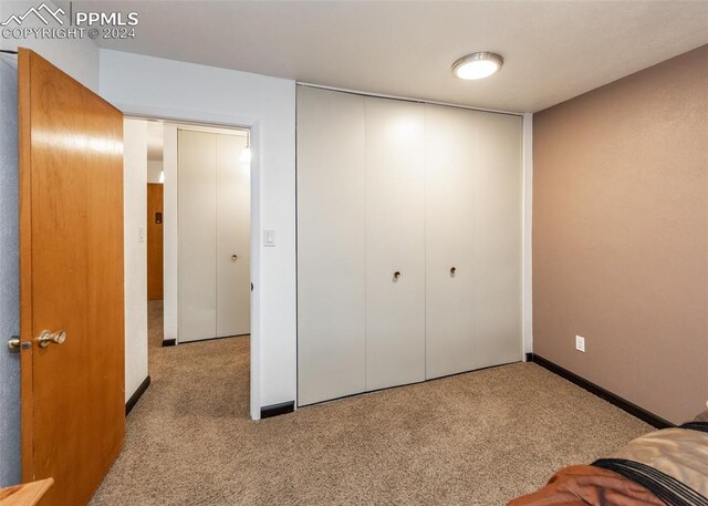 unfurnished bedroom featuring a closet and light carpet