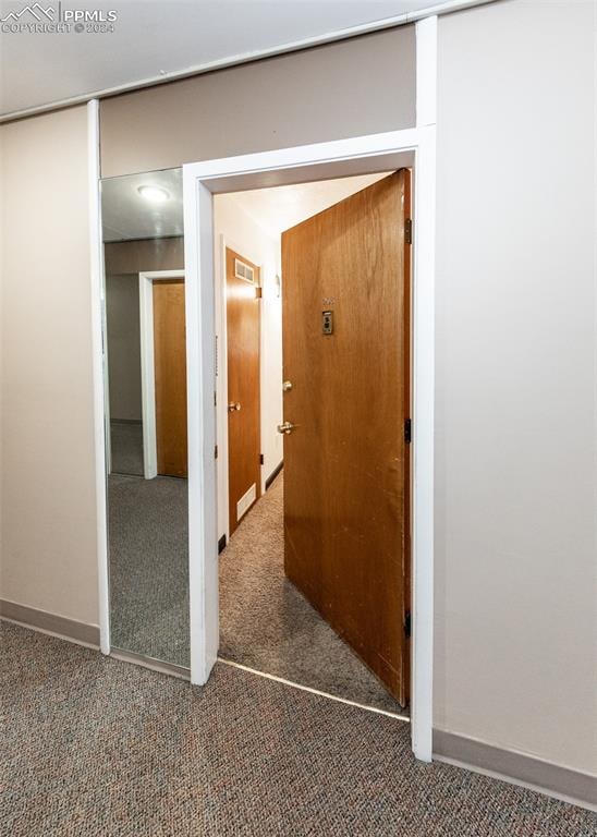 hallway with dark colored carpet