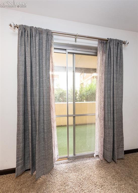 carpeted spare room featuring baseboards