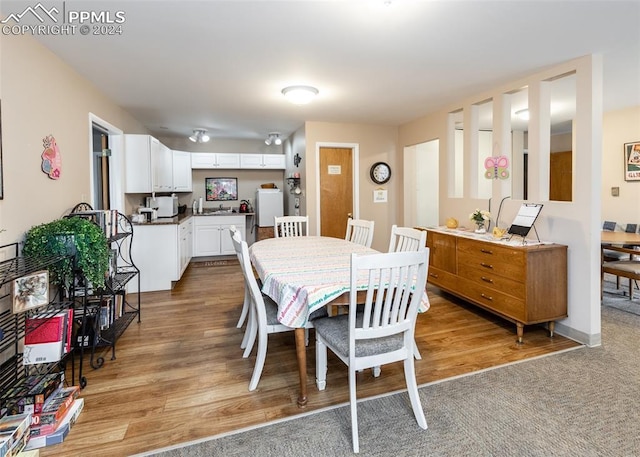 dining room featuring light wood-type flooring and baseboards