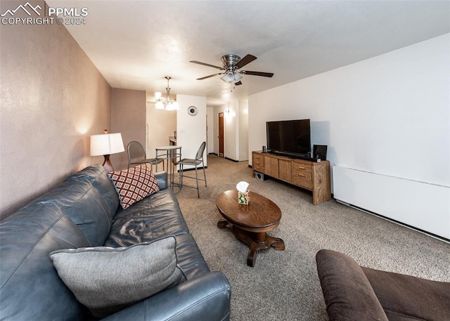 carpeted living room featuring ceiling fan with notable chandelier