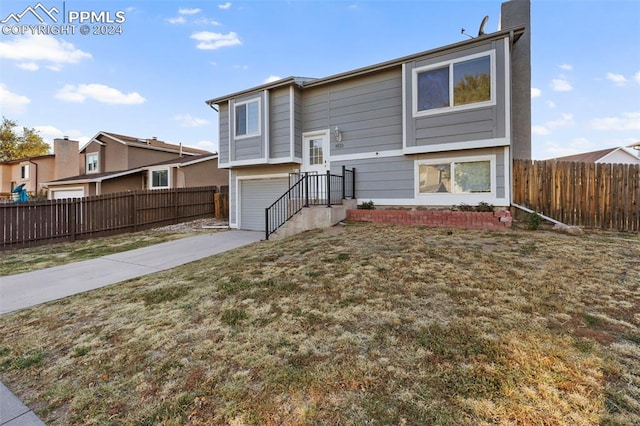 rear view of house with a yard and a garage