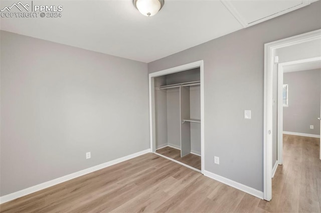 unfurnished bedroom with light hardwood / wood-style floors and a closet