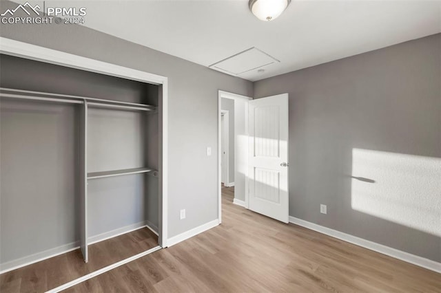 unfurnished bedroom featuring hardwood / wood-style floors and a closet