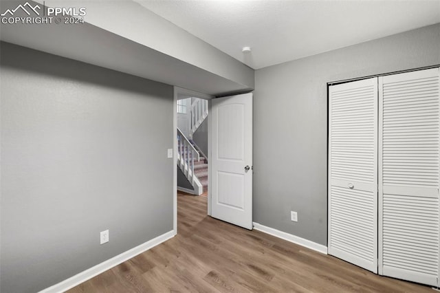 unfurnished bedroom with a closet and light wood-type flooring