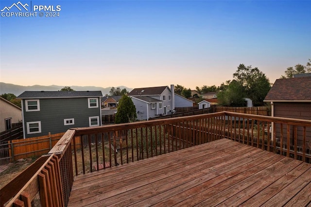 deck at dusk featuring a mountain view