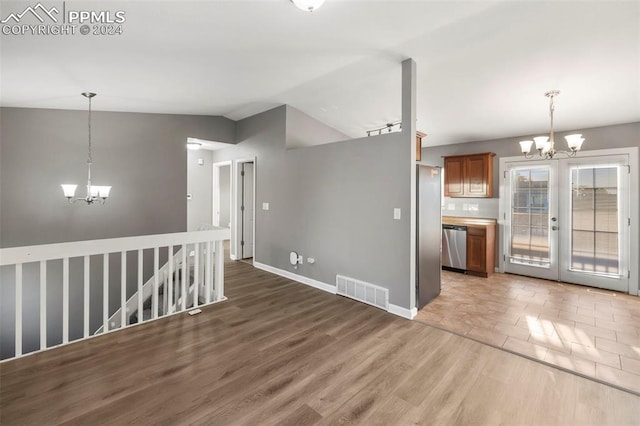 interior space featuring hardwood / wood-style flooring, vaulted ceiling, and an inviting chandelier