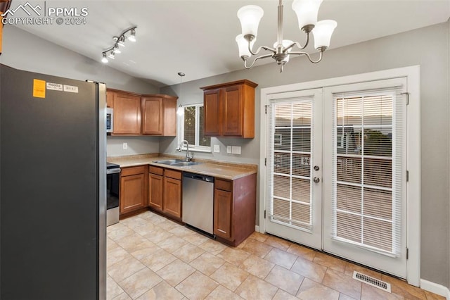 kitchen featuring a wealth of natural light, sink, vaulted ceiling, pendant lighting, and appliances with stainless steel finishes