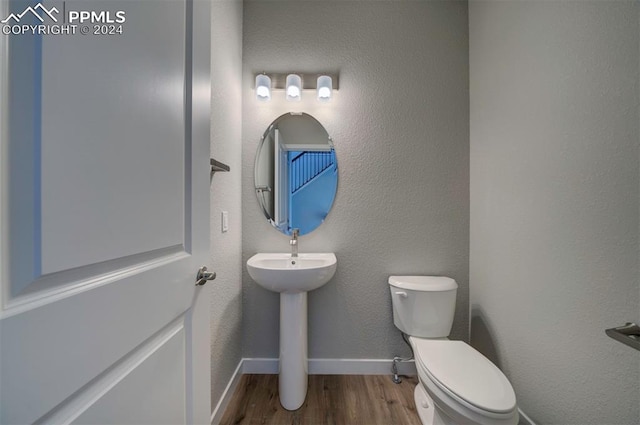 bathroom featuring toilet and wood-type flooring