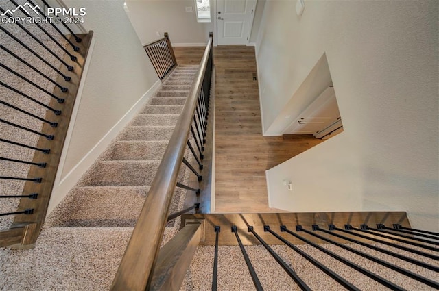 stairway featuring hardwood / wood-style flooring and a high ceiling