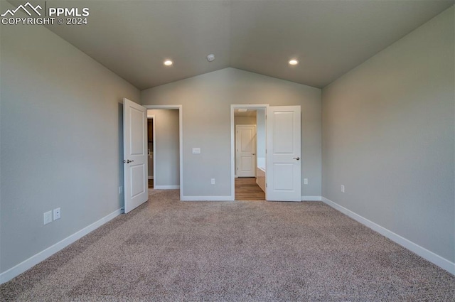 unfurnished bedroom featuring carpet flooring and lofted ceiling