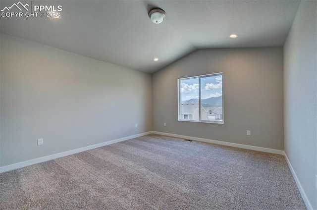 spare room with carpet floors and lofted ceiling