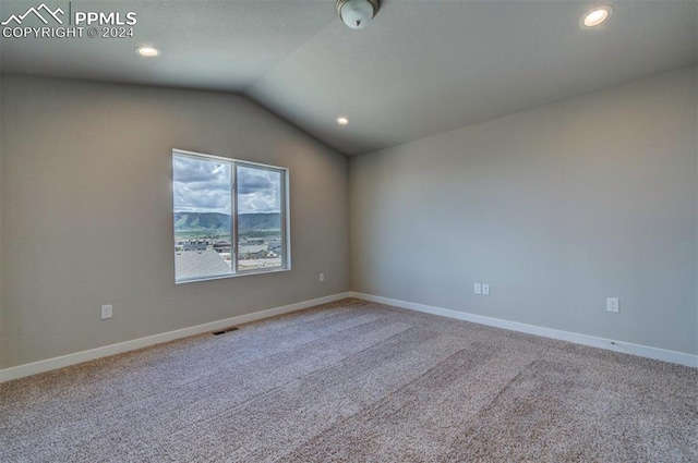 unfurnished room featuring carpet and lofted ceiling