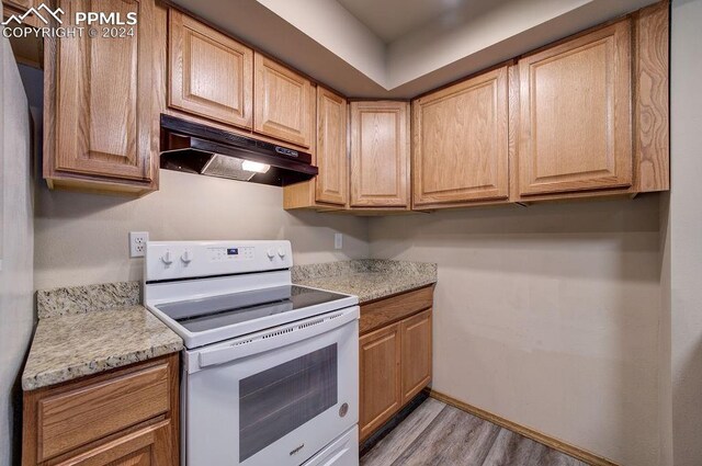 kitchen featuring white electric stove and light hardwood / wood-style flooring