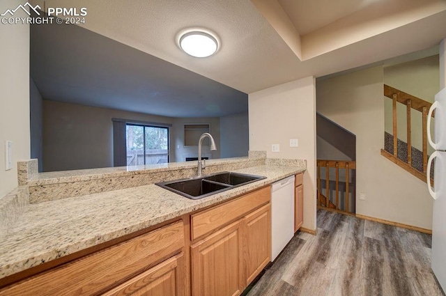 kitchen with sink, white dishwasher, dark hardwood / wood-style floors, and light stone countertops