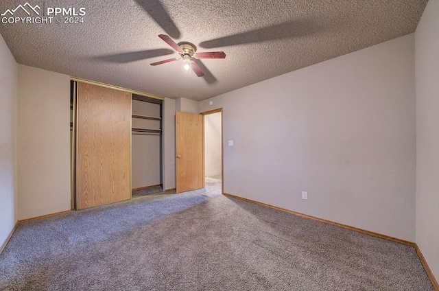 unfurnished bedroom with ceiling fan, carpet flooring, a textured ceiling, and a closet