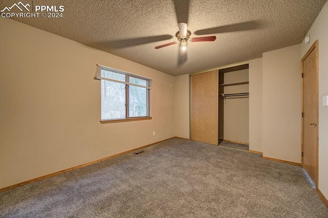 unfurnished bedroom featuring ceiling fan, a closet, a textured ceiling, and carpet floors