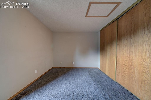 interior space with a textured ceiling, carpet, visible vents, and baseboards