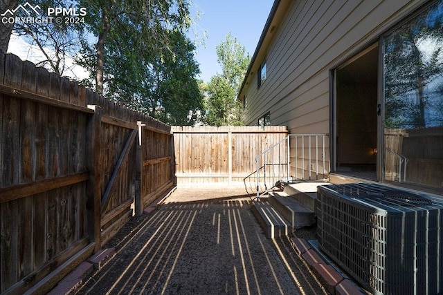 wooden terrace featuring a fenced backyard and central AC unit