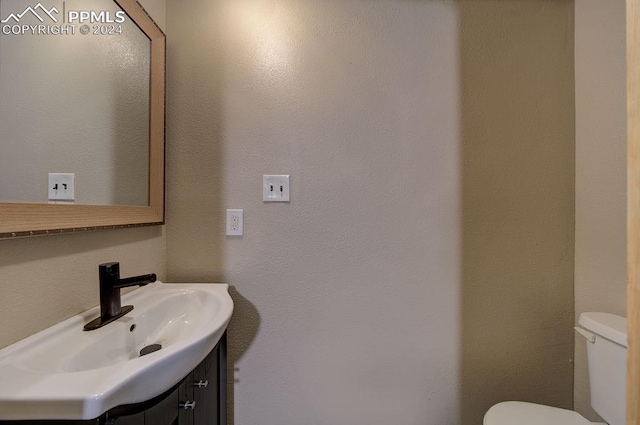 half bathroom with vanity and toilet