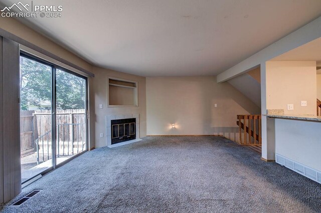 unfurnished living room featuring carpet, lofted ceiling with beams, and a tile fireplace