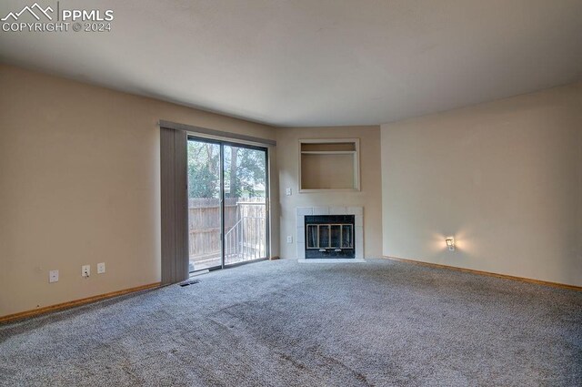 unfurnished living room with carpet floors and a tile fireplace