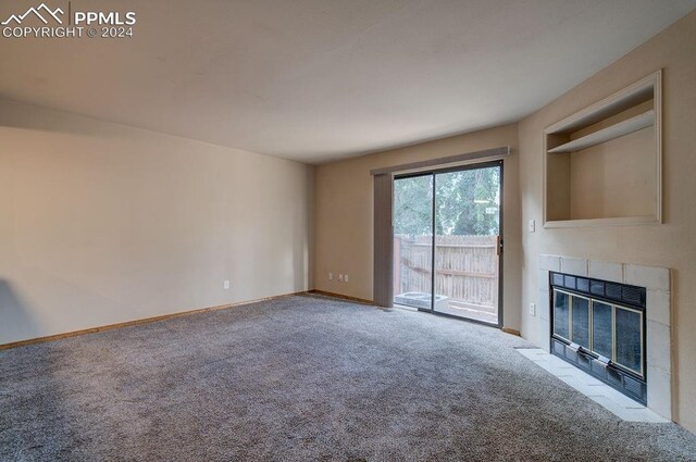 unfurnished living room featuring light carpet and a tile fireplace