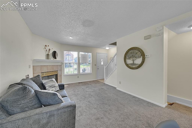 carpeted living room with a textured ceiling and a fireplace