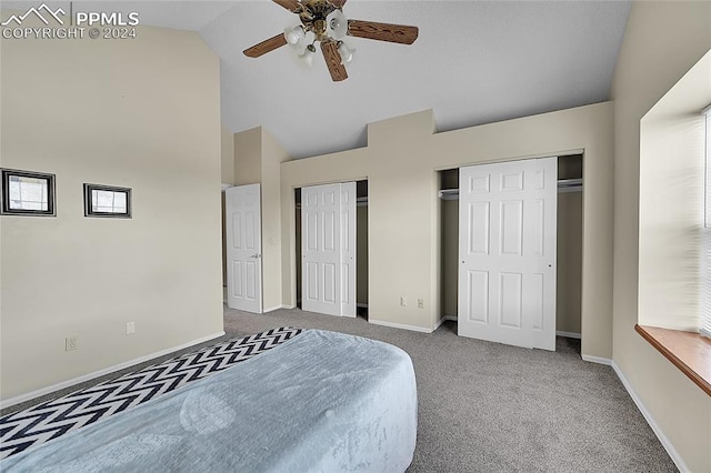 carpeted bedroom featuring high vaulted ceiling, ceiling fan, and multiple closets