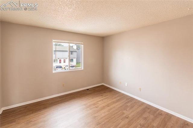 unfurnished room featuring a textured ceiling and hardwood / wood-style flooring