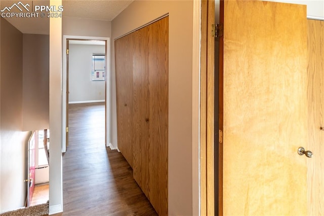 hallway featuring a textured ceiling and hardwood / wood-style floors