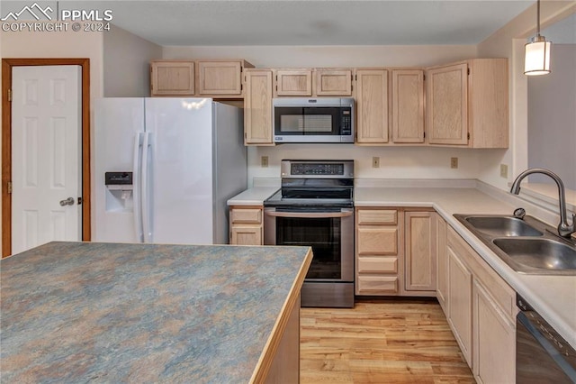 kitchen featuring light brown cabinetry, light wood-type flooring, sink, and appliances with stainless steel finishes