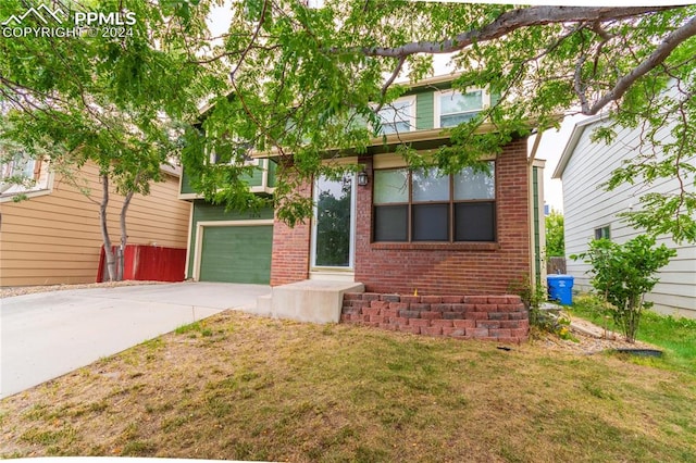 view of front of property with a garage and a front lawn