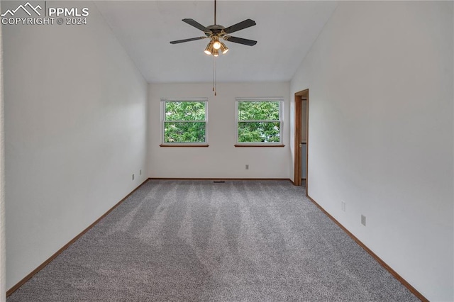 empty room with lofted ceiling, ceiling fan, and carpet