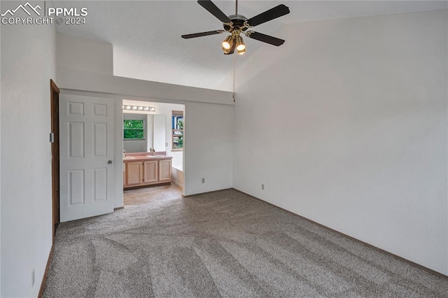 interior space with light colored carpet, ceiling fan, and high vaulted ceiling