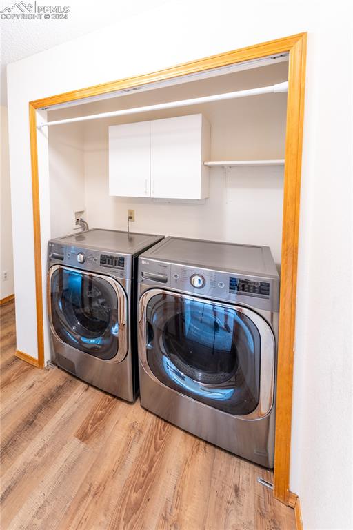 laundry room featuring independent washer and dryer and light wood-type flooring