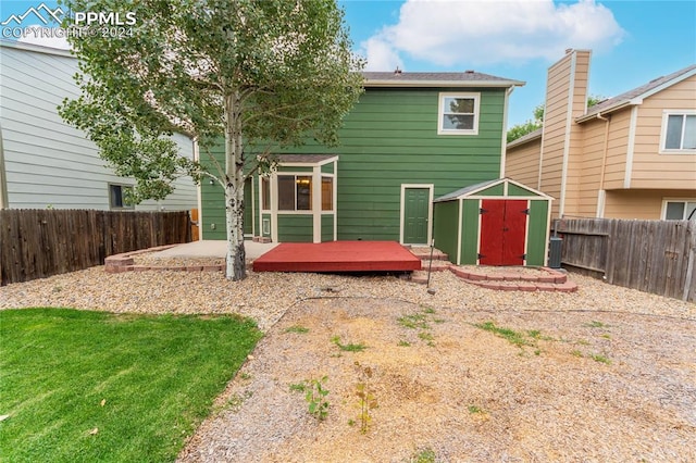 rear view of house featuring a storage unit, a yard, and a patio area