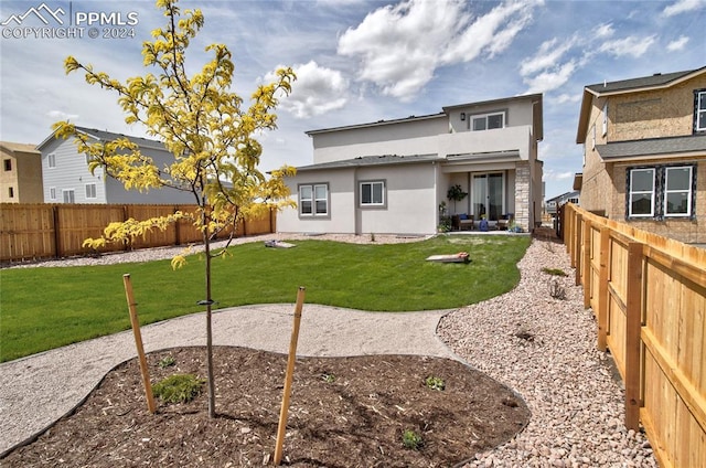 back of property with stucco siding, a patio, a lawn, and a fenced backyard