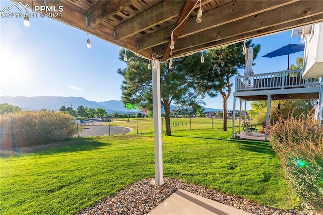 view of yard with a deck with mountain view