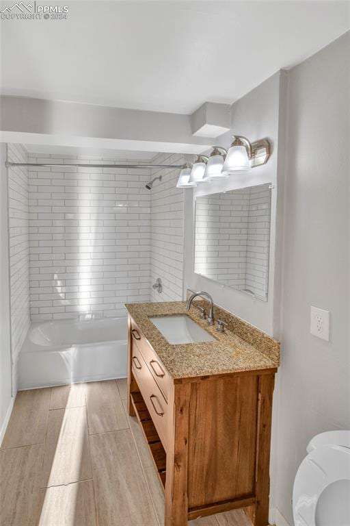 bathroom featuring vanity and tiled shower / bath