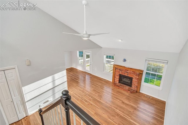 living room featuring a healthy amount of sunlight, ceiling fan, hardwood / wood-style flooring, and a fireplace